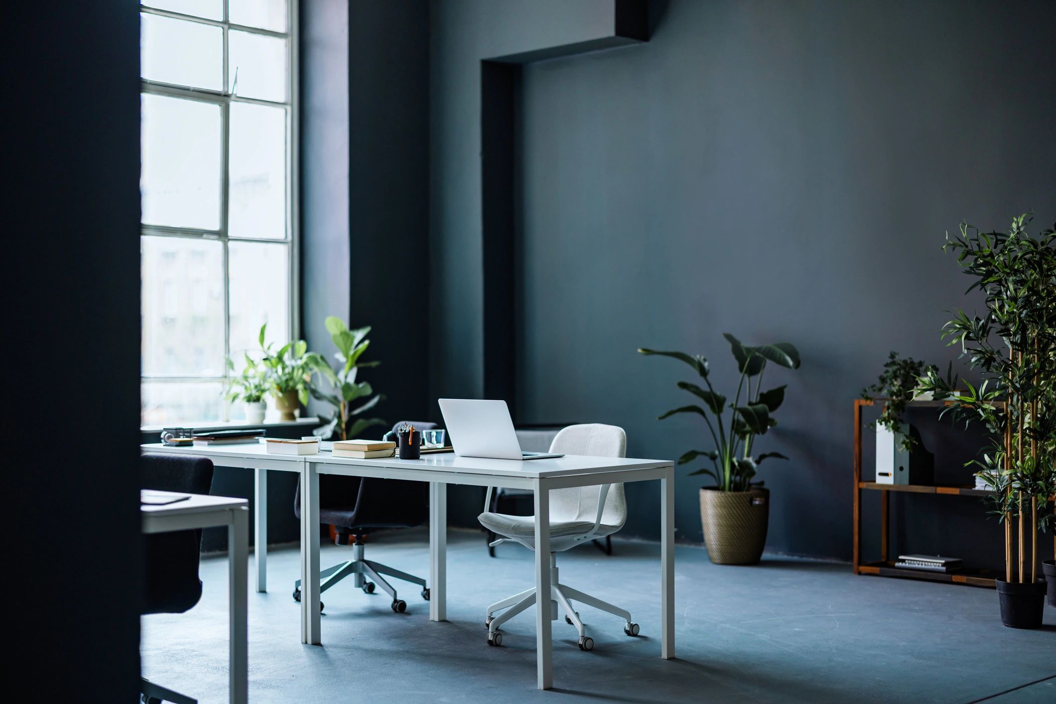 Modern workspace with laptop and office supplies near a large window
