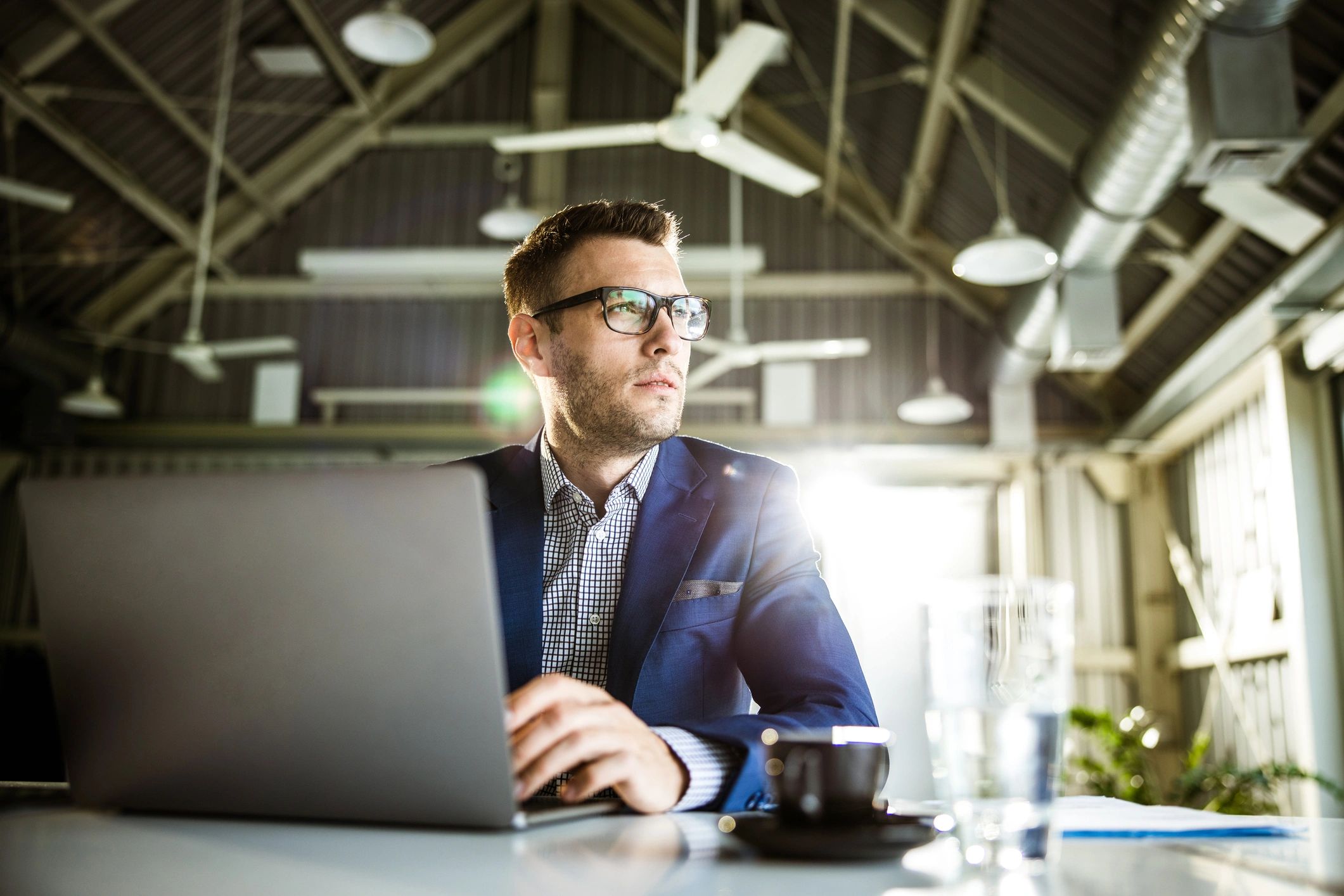 Thoughtful businessman working on laptop in the office
