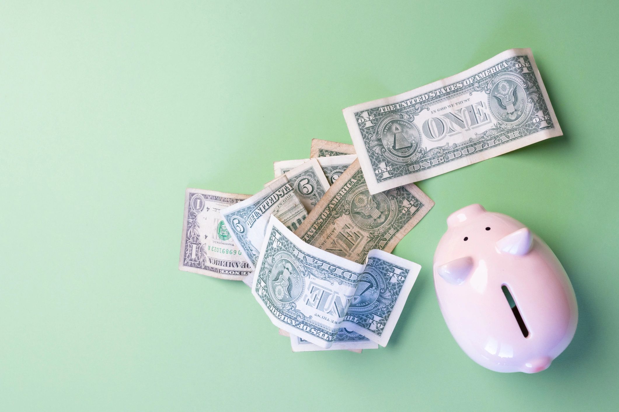 Piggy bank next to dollar bills for saving and budgeting